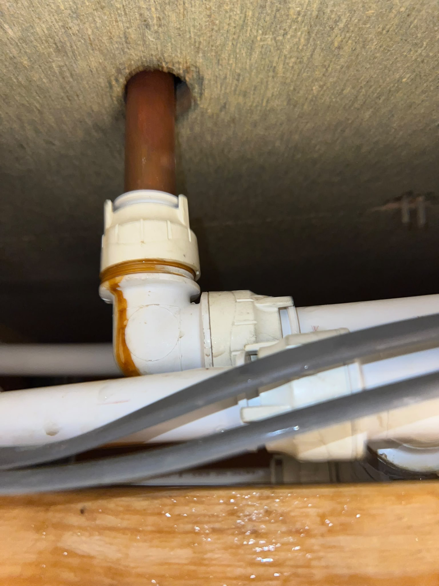 Push-fit elbow leaking brown water under a floor