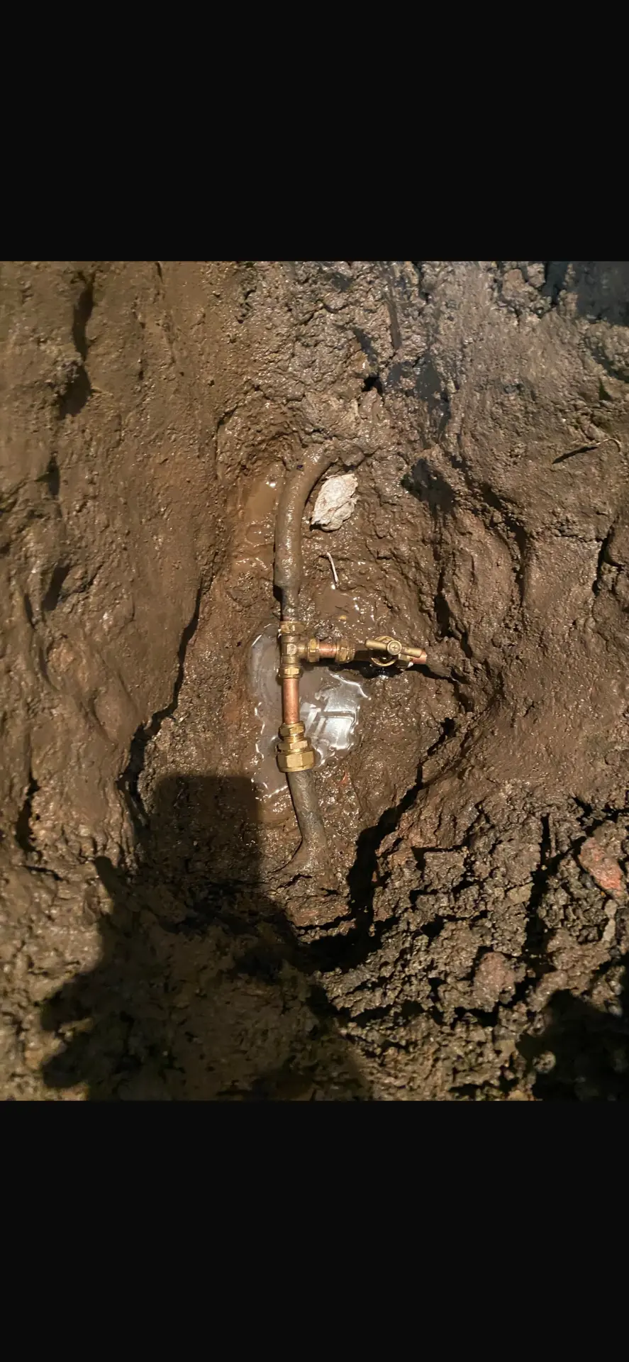 Repaired supply pipe with new fittings in the excavation